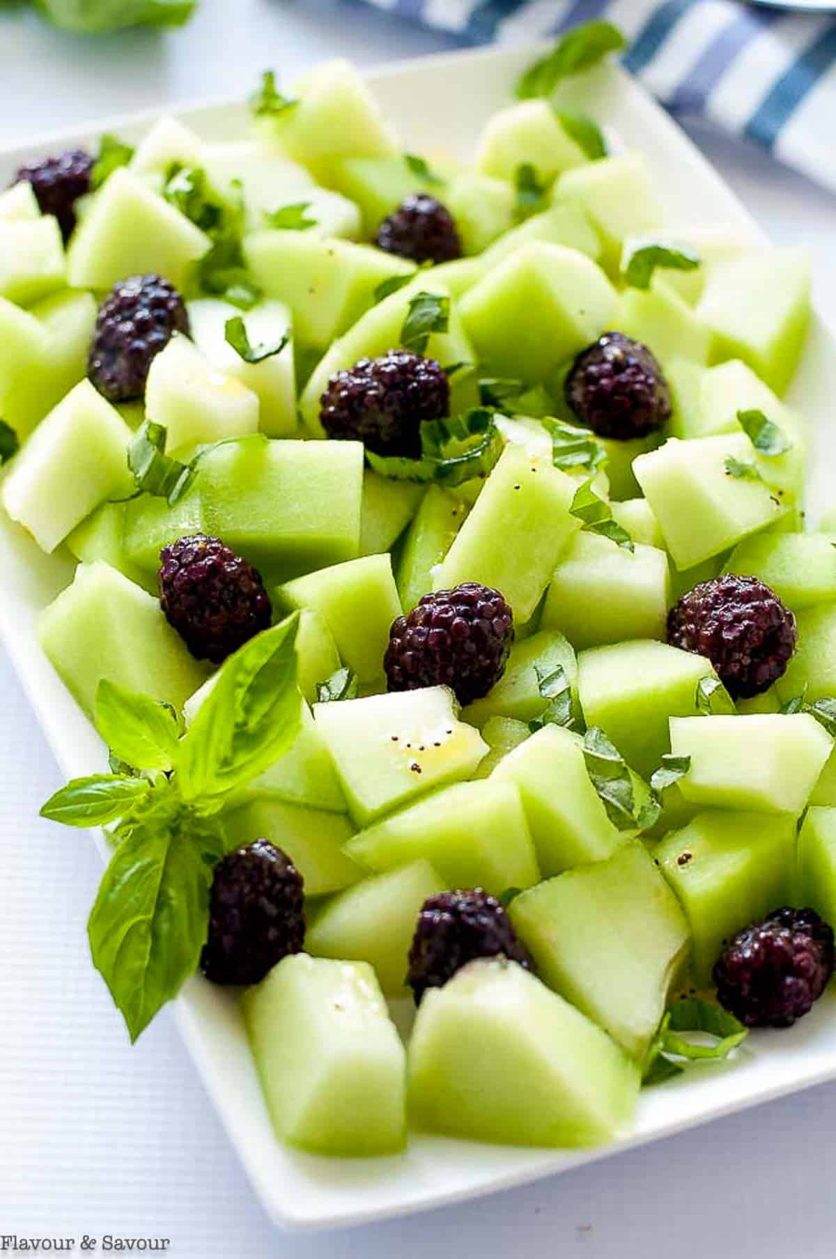 Honeydew Blackberry Salad with fresh basil leaves.