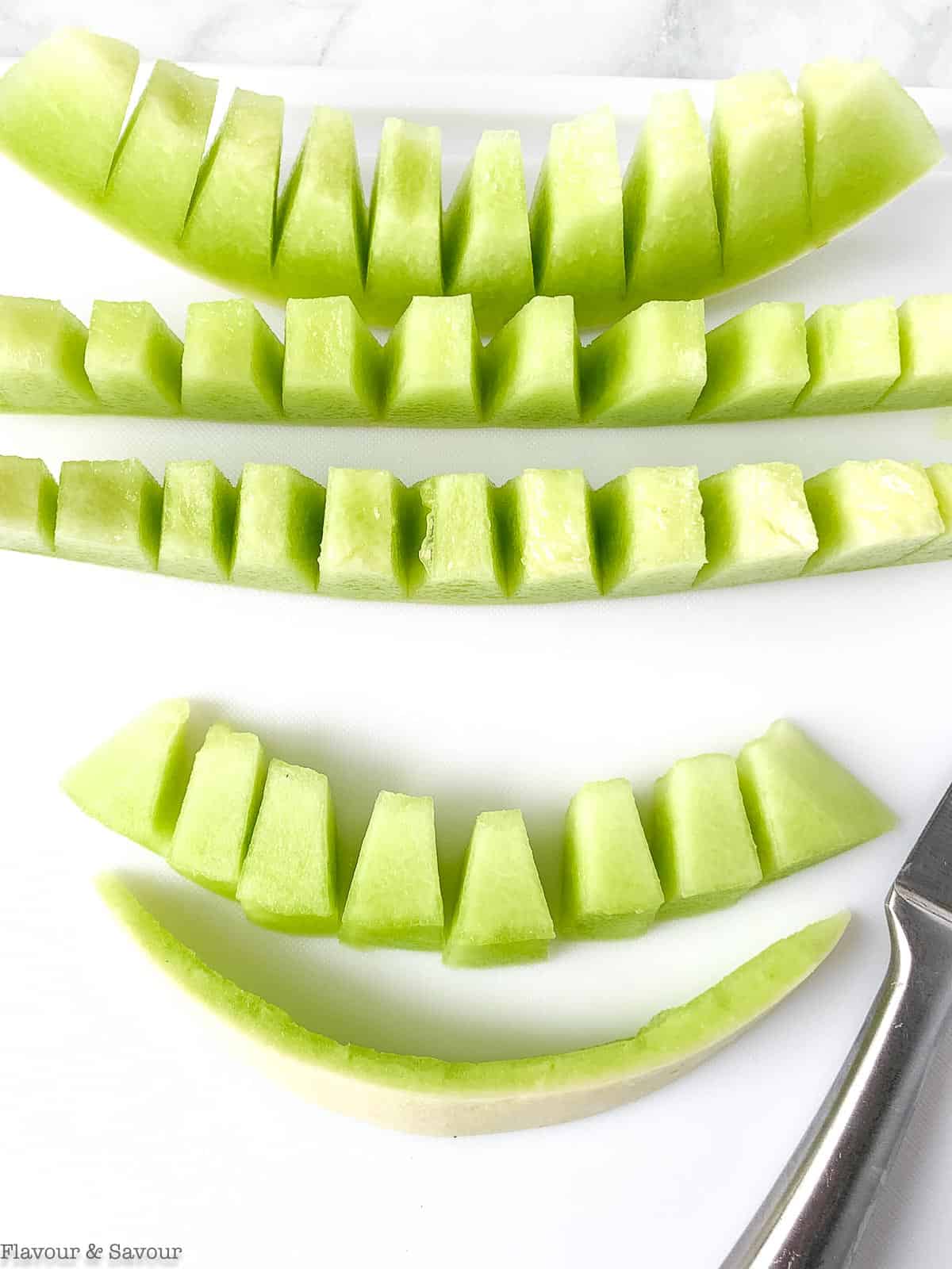 Removing rind from honeydew melon.