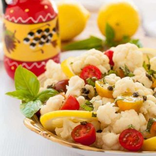 Cauliflower Lemon Basil Salad with toasted capers, fresh basil and cherry tomatoes in a bowl.