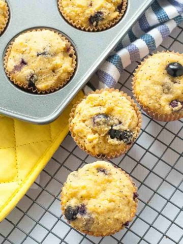 Paleo Blueberry Lemon Poppy Seed Muffins cooling on a rack.