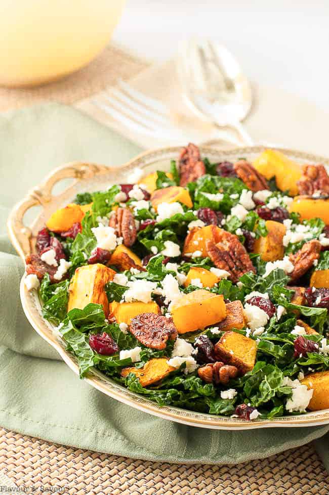 Butternut Squash Salad with Cranberries and Feta in a gold-rimmed dish on a green cloth