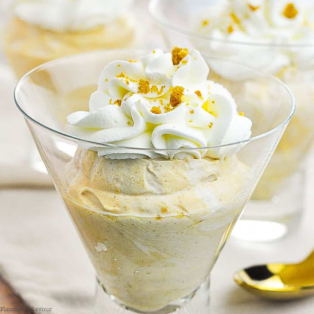pumpking cheesecake mousse topped with whipped cream in a dessert glass