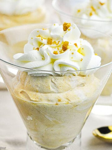 pumpkin cheesecake mousse topped with whipped cream in a dessert glass