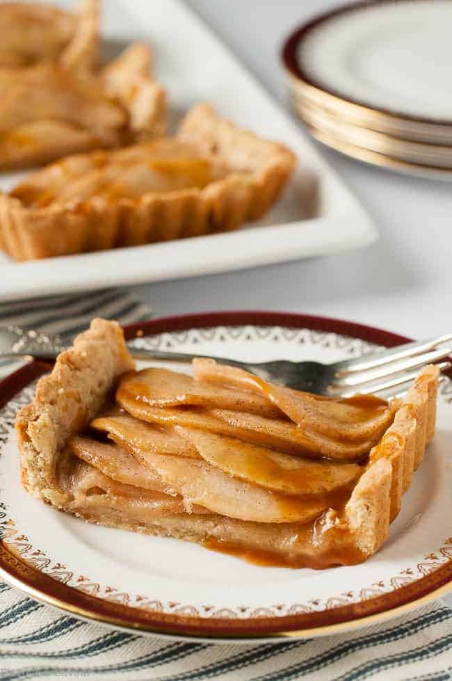 One serving of Gluten Free Cinnamon Pear Tart with Caramel Sauce on a china plate