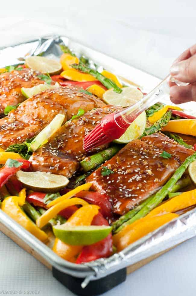 Brushing glaze on to salmon fillets to make Thai Chili Sheet Pan Salmon