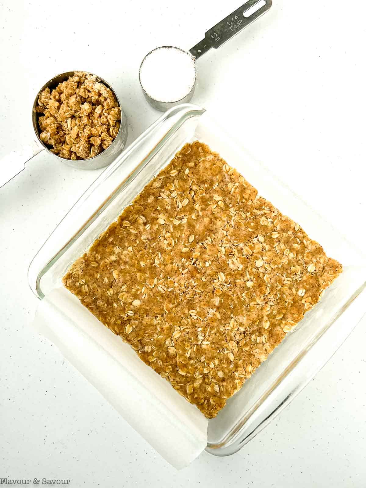 Oatmeal base pressed into a baking pan for cranberry bars.