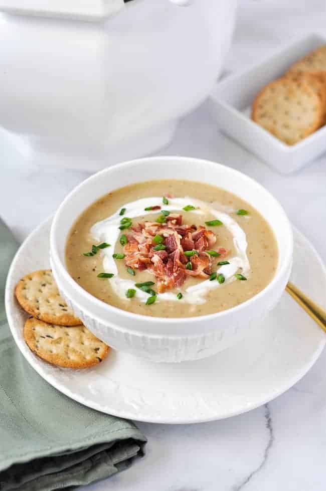 Potato Soup garnished with bacon and chives and a swirl of sour cream.
