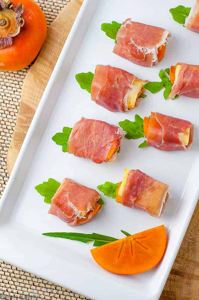 Overhead view of Persimmon Prosciutto Cheese Bites on a white platter