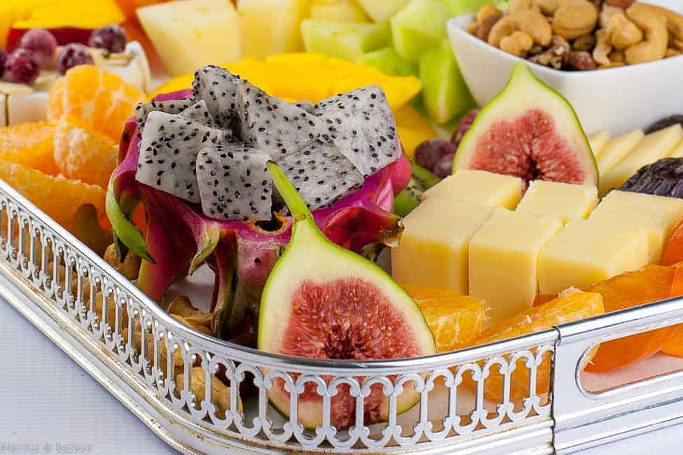 Close up view of Tropical Fruit, Nut and Cheese Platter with fresh figs and dragon fruit in the foreground