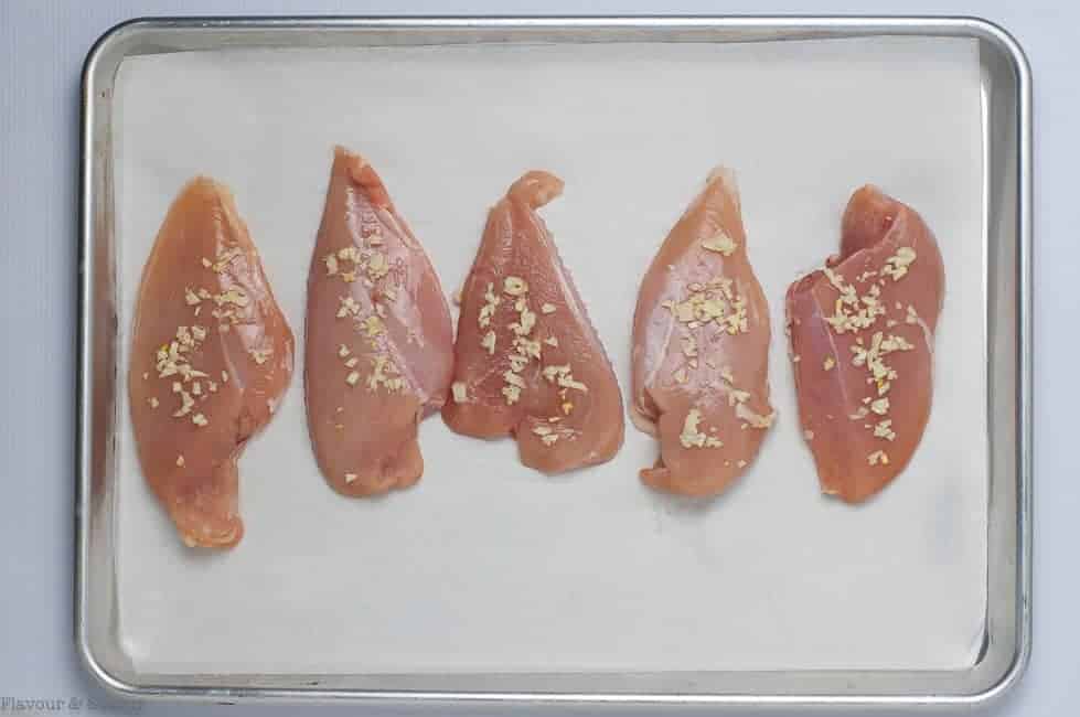 Preparing Raw Chicken Breasts for Prosciutto and Cheesy Chicken Sheet Pan Dinner