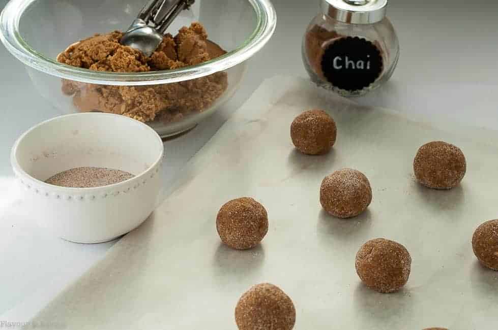 Preparing Gluten-Free Chai Spiced Snickerdoodles by rolling and coating in cinnamon-sugar mix