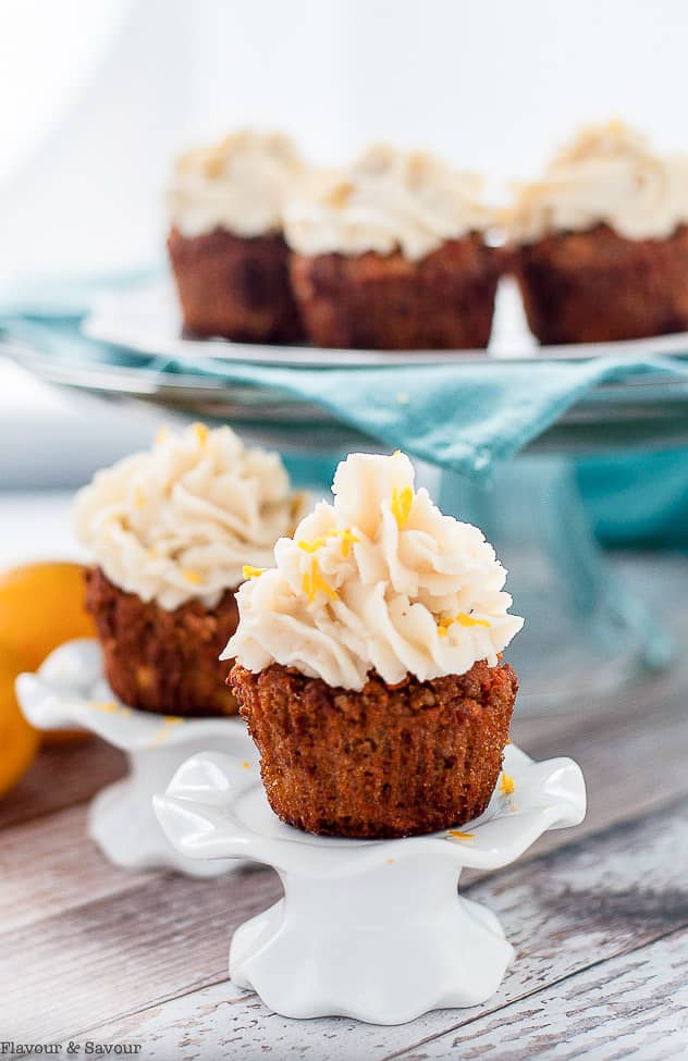 Two carrot cake cupcakes on cupcake pedestals