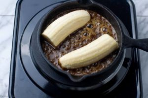 adding bananas to Caribbean Rum Bananas Flambé with Amaretto