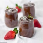 3 small dessert glasses with dairy-free vegan chocolate mousse with fresh strawberries