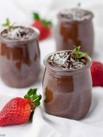 3 small dessert glasses with dairy-free vegan chocolate mousse with fresh strawberries