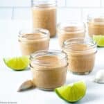 jars of peanut sauce with coconut milk with lime slices on the counter