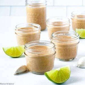 jars of peanut sauce with coconut milk with lime slices on the counter