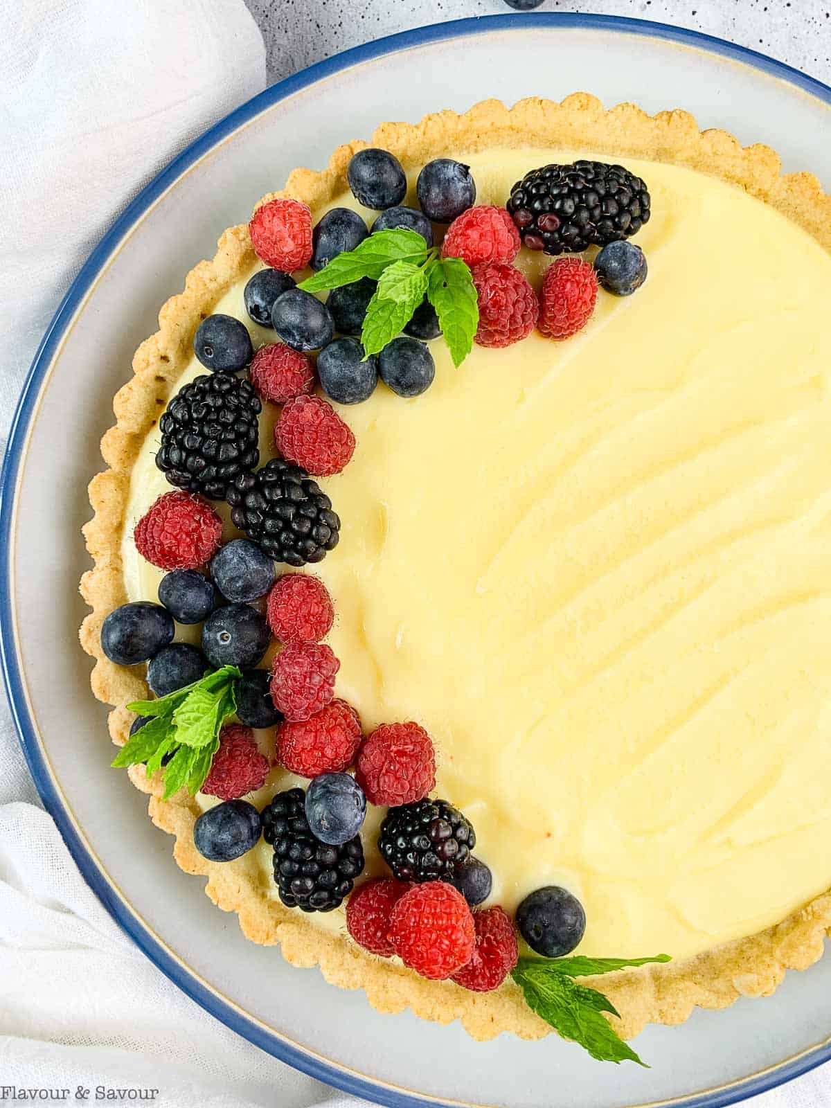 Overhead view of gluten-free lemon curd tart with fresh berries