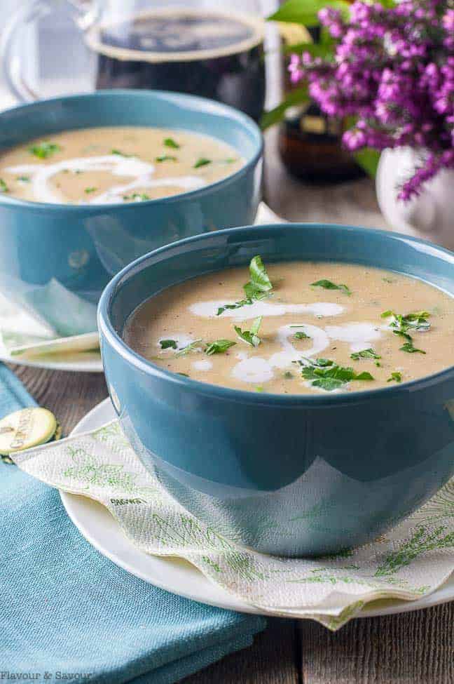 Close up view of Creamy Roasted Garlic Irish Potato Soup in turquoise bowls