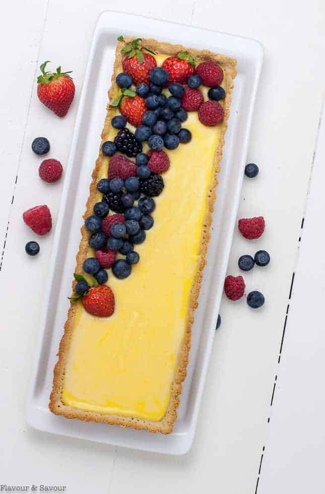 Gluten-Free Lemon Curd Tart with Berries in a rectangular tart pan, overhead view