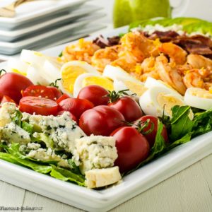 Side view of Shrimp Cobb Salad on a platter with ingredients in rows