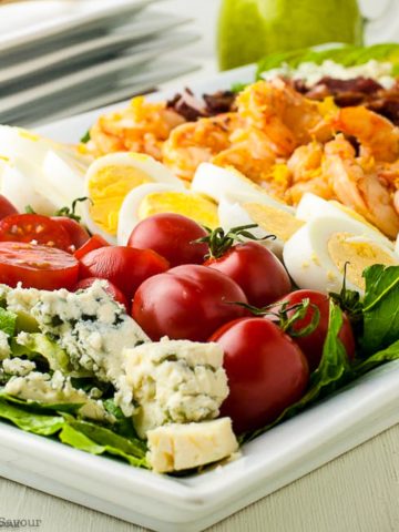 Side view of Shrimp Cobb Salad on a platter with ingredients in rows