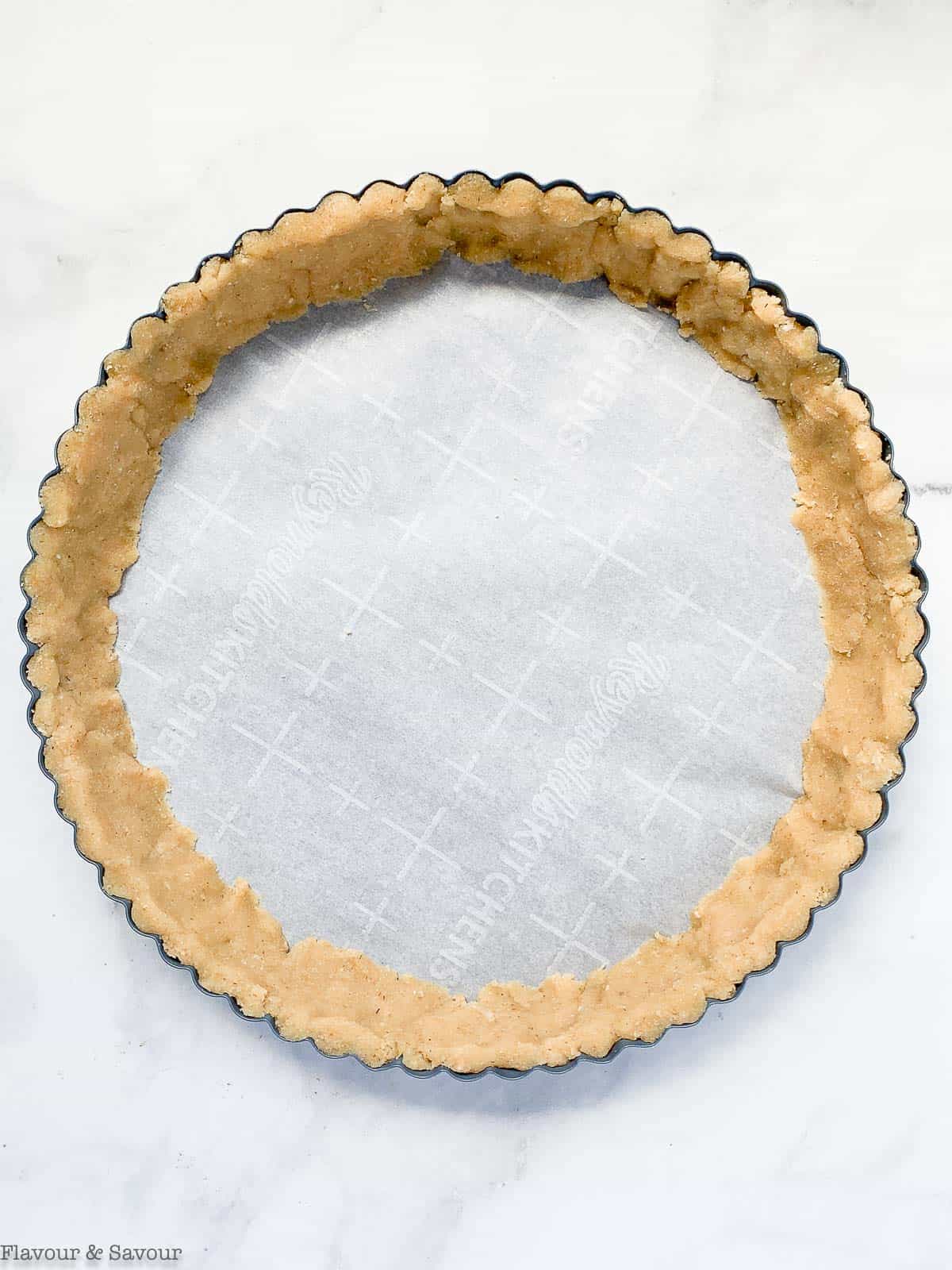 Pressing almond flour crust into edges of pan.