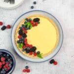 Lemon Curd Tart in a round pan with fresh berries