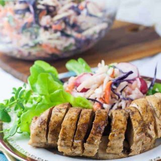 Instant Pot Caribbean Jerk Chicken Breasts sliced on a plate with coleslaw.