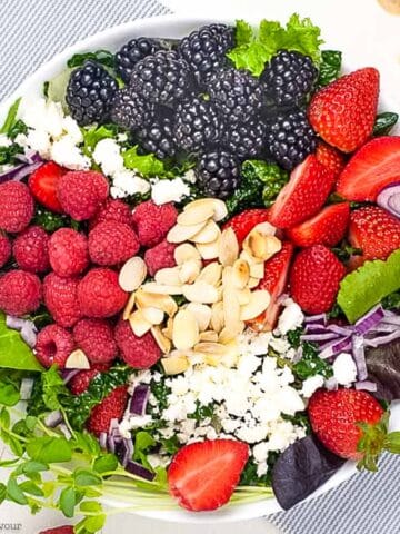 overhead view of mixed green salad with berries