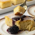 Close up view of a forkful of Flourless Lemon Almond Ricotta Cake with Blackberry Coulis