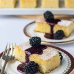 Flourless Lemon Almond Ricotta Cake with Blackberry Coulis on a plate with a fork