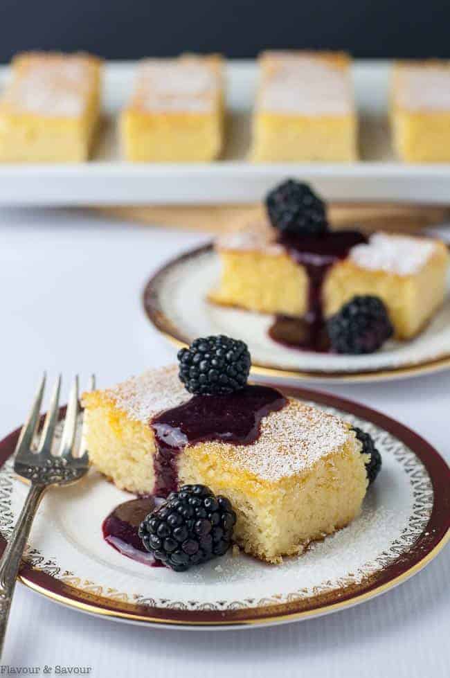 Flourless Lemon Almond Ricotta Cake with Blackberry Coulis on a plate with a fork
