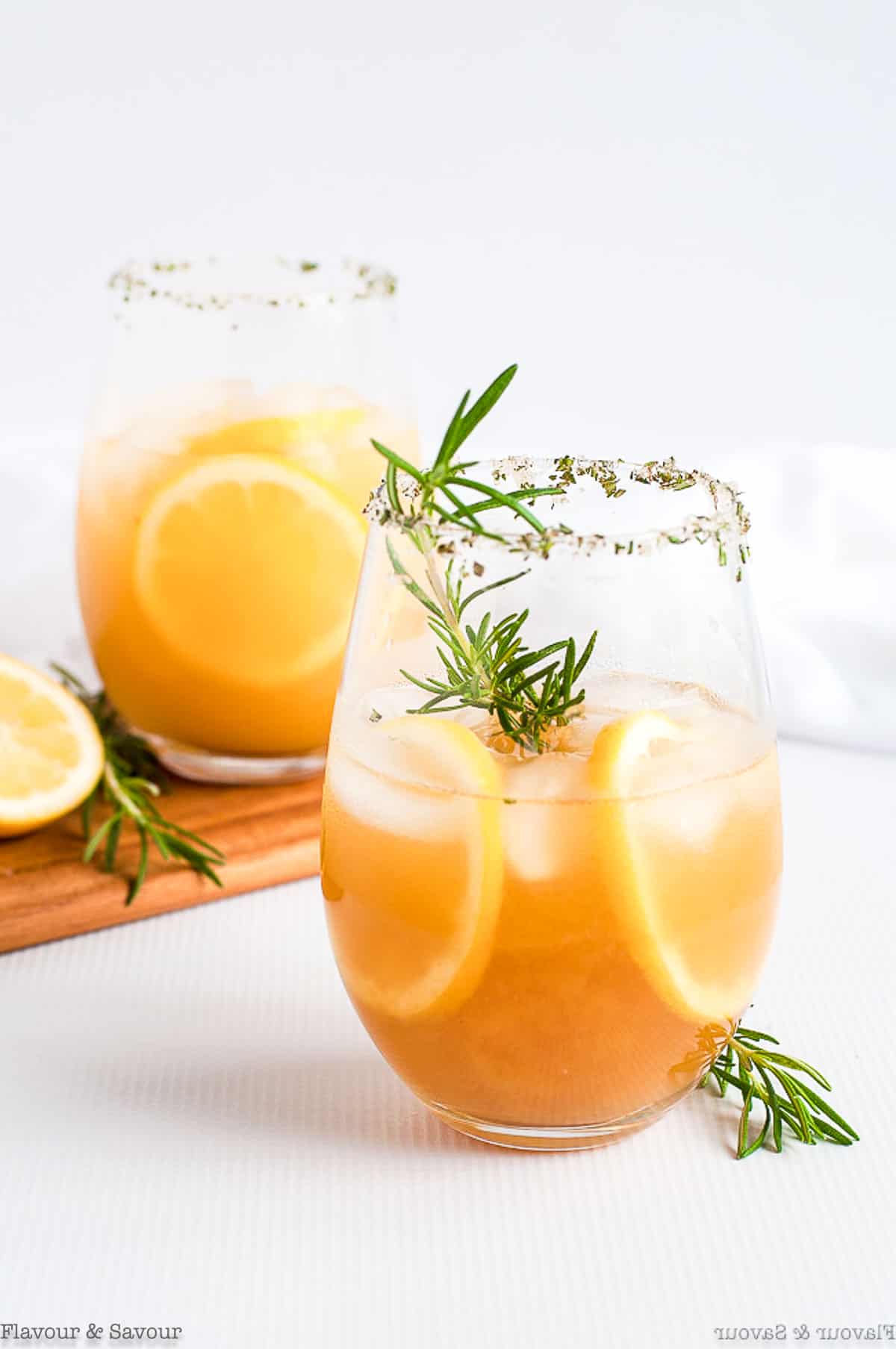 A glass of Pineapple Ginger Kombucha Cocktail garnished with rosemary