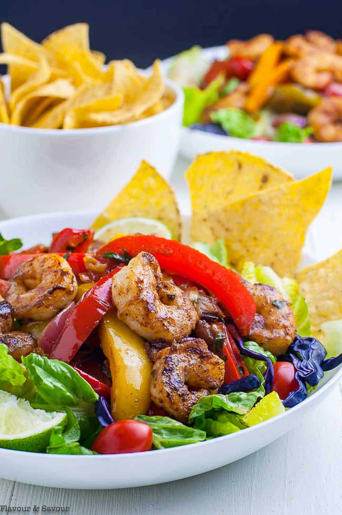 Close up view of Shrimp Fajita Salad with peppers and tortilla chips