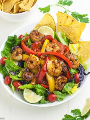 overhead view of Shrimp Fajita Salad in a white bowl with tortilla chips