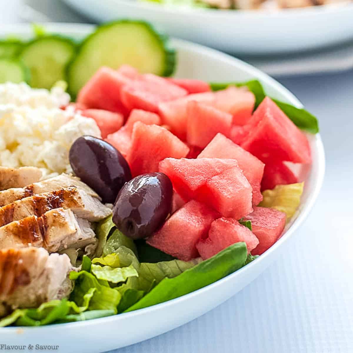Greek chicken bowl with watermelon olives and feta cheese.