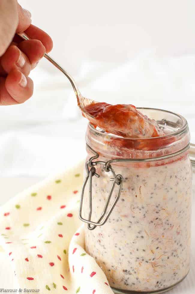 A spoonful of creamy Strawberry Rhubarb Chia Overnight Oats in a jar