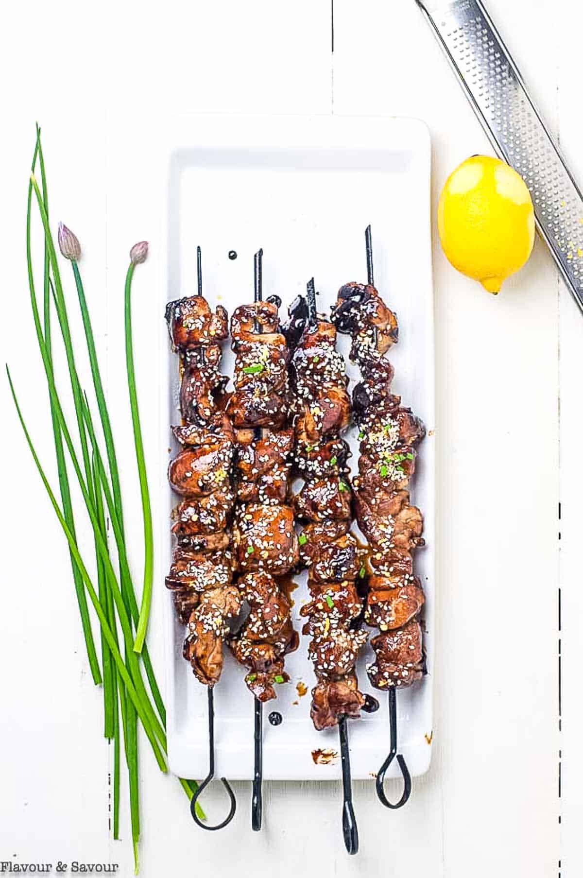 Overhead view of Easy Japanese Yakitori Skewers with chive blossoms.