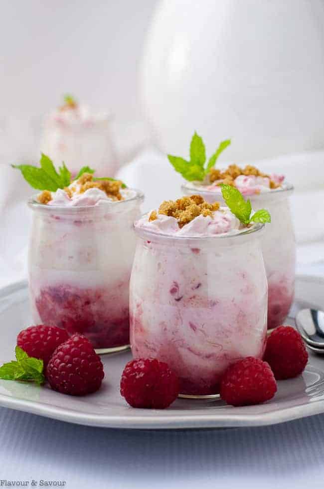 Easy Raspberry Rhubarb Fool in mini dessert glasses garnished with mint and fresh raspberrie.s