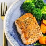 Fennel Crusted Salmon with broccoli on a blue stoneware plate