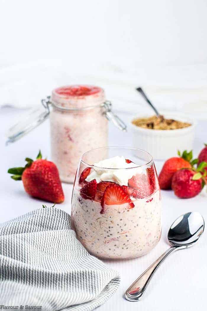 Strawberry Rhubarb Chia Overnight Oats in a clear glass with fresh strawberries