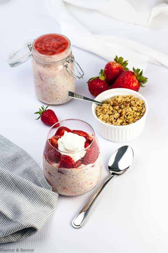 Overhead view of strawberry rhubarb overnight oats with granola and fresh strawberries