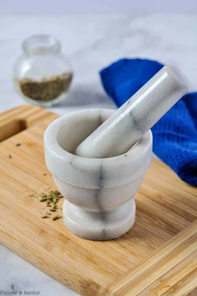 grinding fennel seeds with a mortar and pestle