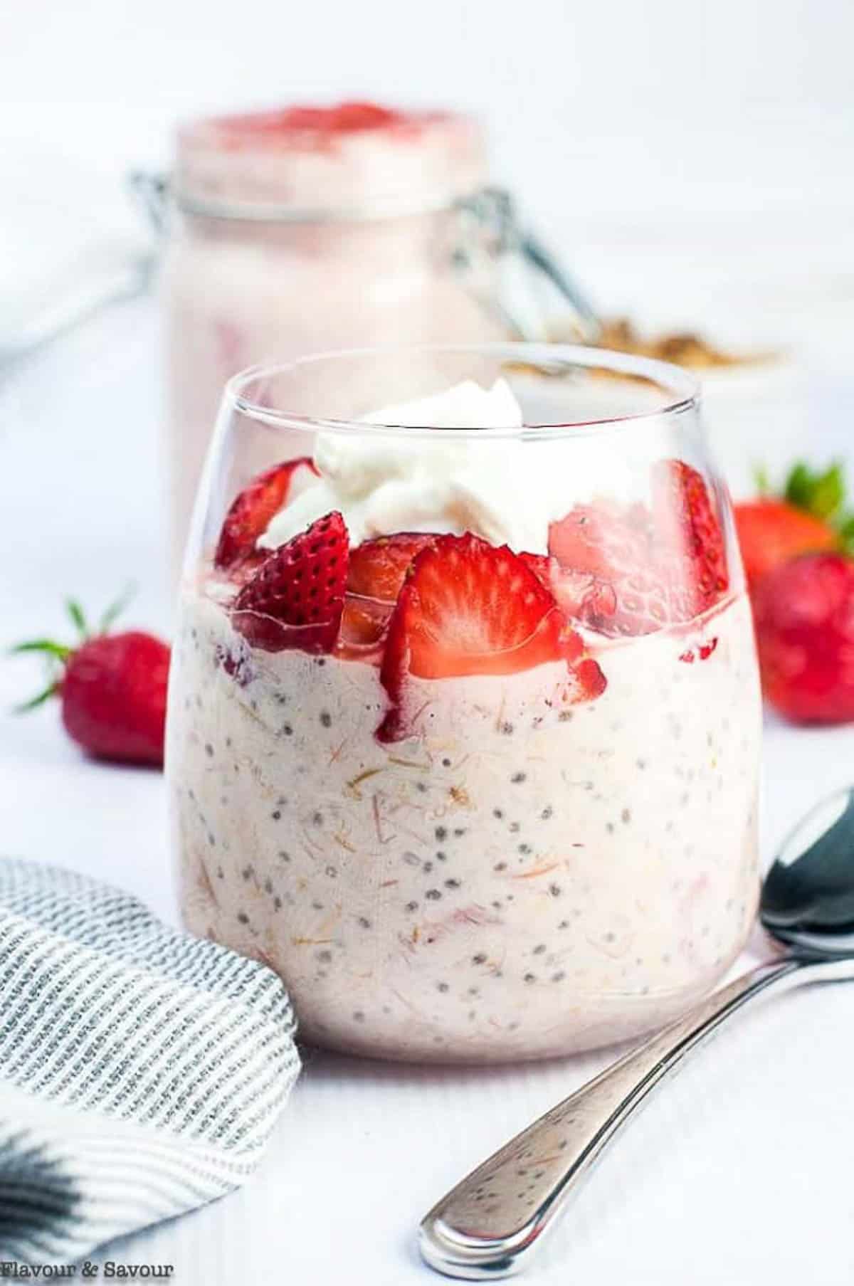 Close up view of a dessert glass filled with strawberry rhubarb overnight oats.