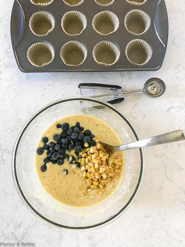 Adding blueberries and corn to  Blueberry Buttermilk Cornbread Muffin batter.