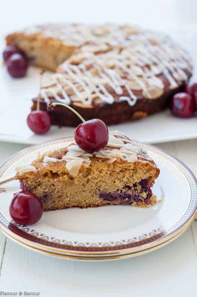 a slice of Flourless Cherry Almond Ricotta Cake with fresh cherries.