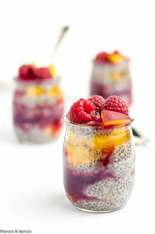Close up view of Raspberry Peach Chia Seed Pudding in small jars.