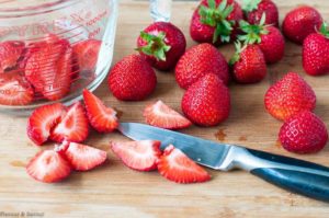 Preparing strawberries for Strawberry Cucumber Salad with Creamy Lemon Dressing