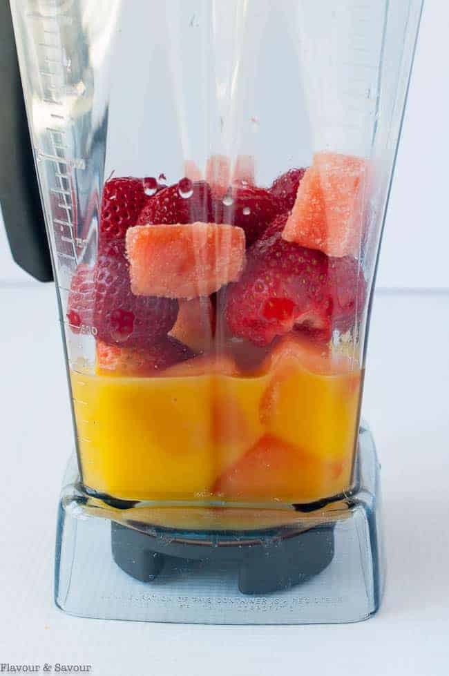 Ingredients for Strawberry Orange Watermelon Collagen Smoothie in a blender, a fruity mocktail recipe.